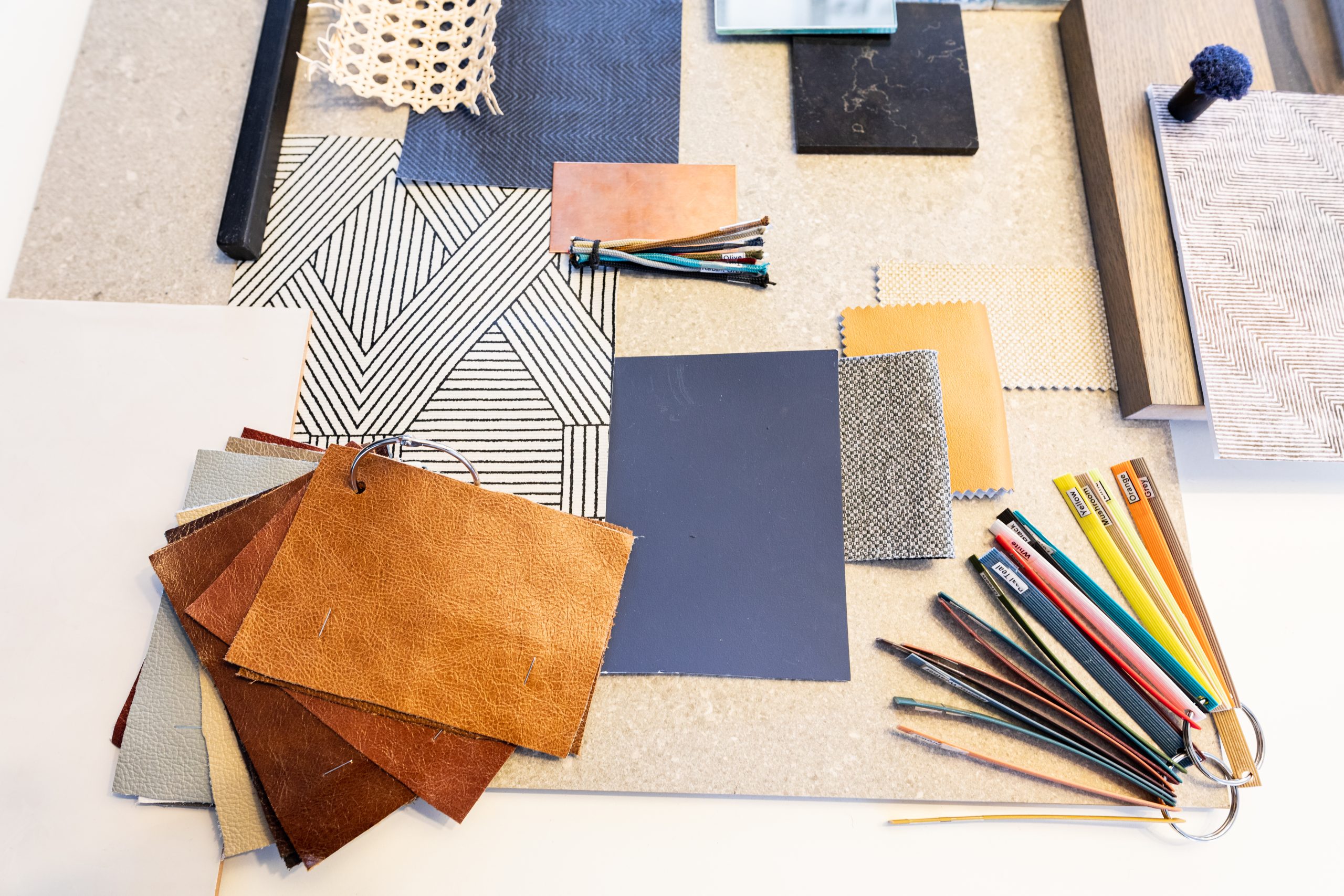 High angle view of various patterned fabric swatches and work tools on table in office. unaltered, business and creative office.